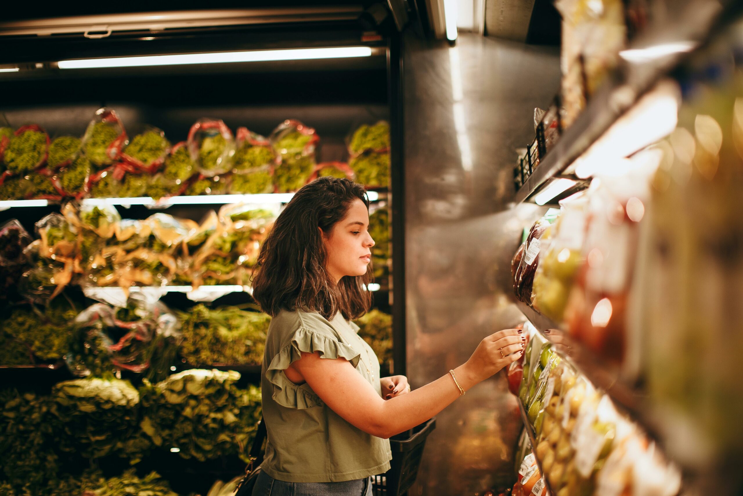 woman-grocery-shopping-in-an-aisle-with-food-that-has-nutrition-labels